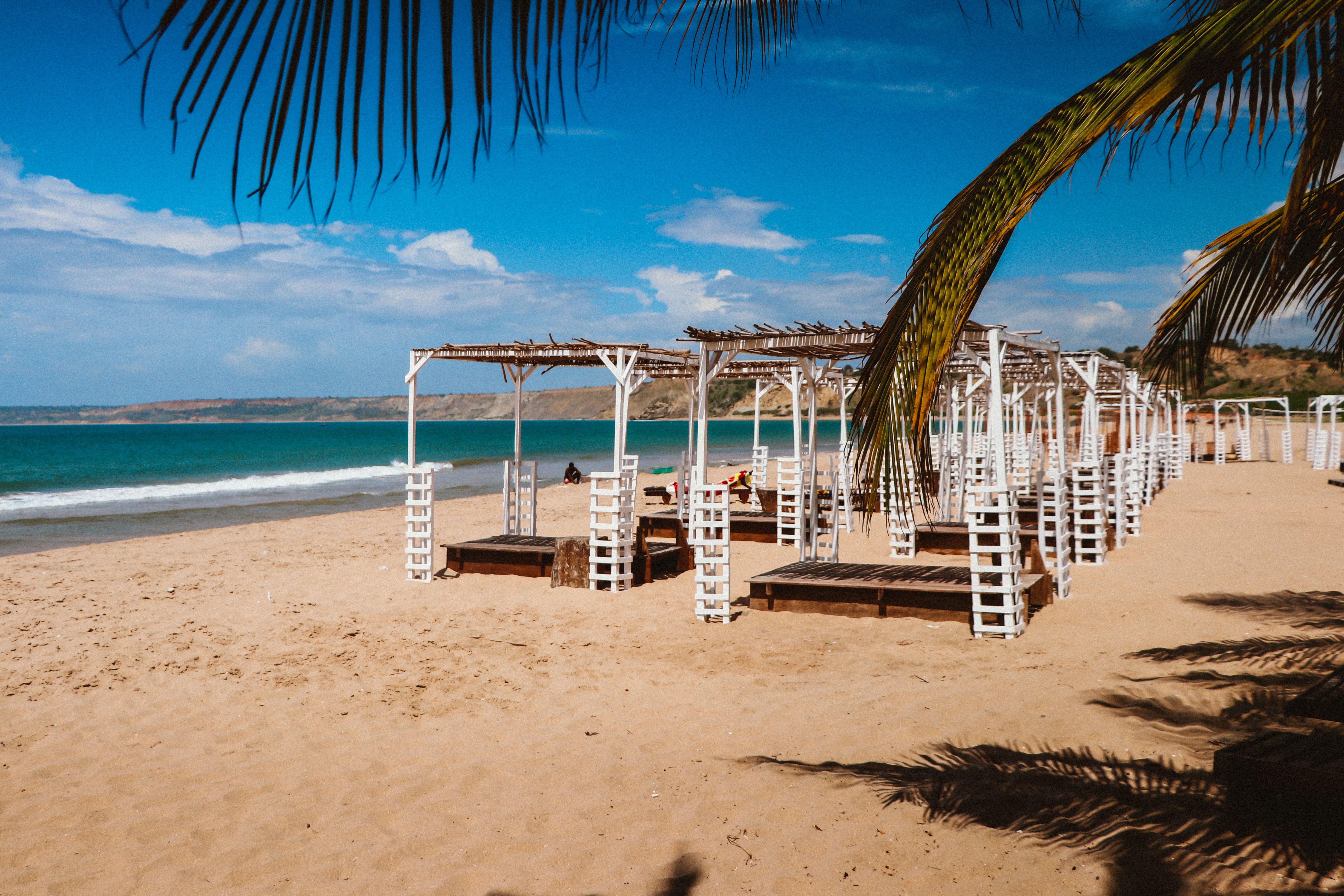 נוסי בה: Relaxing scene of a tropical beach resort with white pergolas and calm turquoise sea.