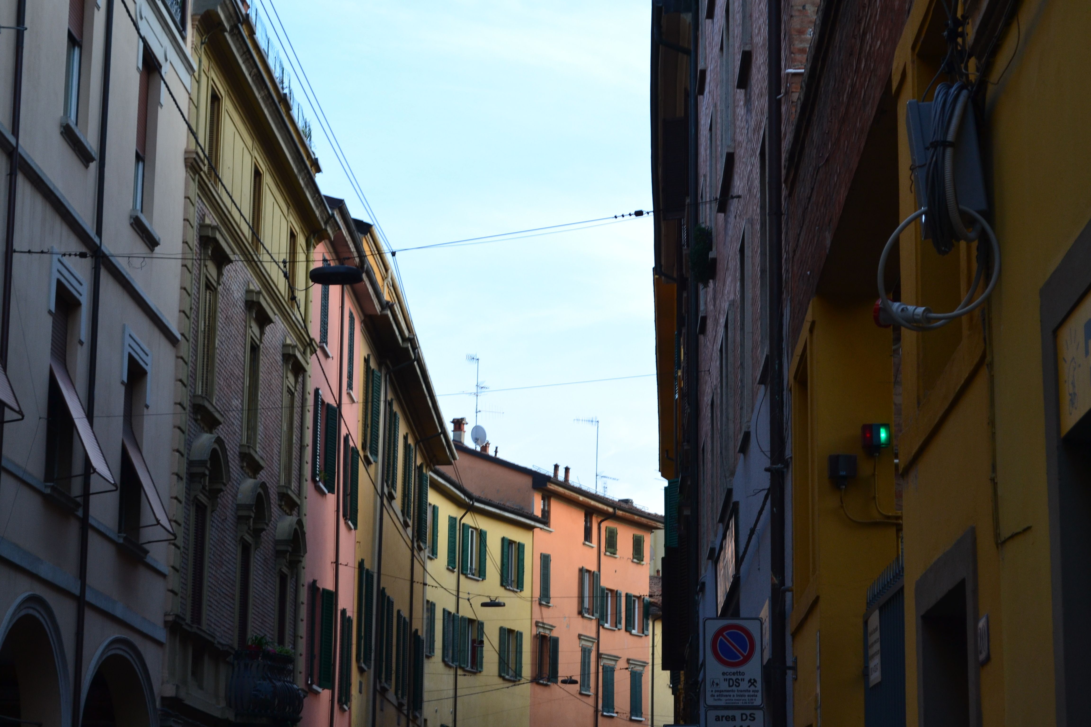 בולוניה: Charming view of vibrant buildings lining a narrow street in Bologna, Italy.