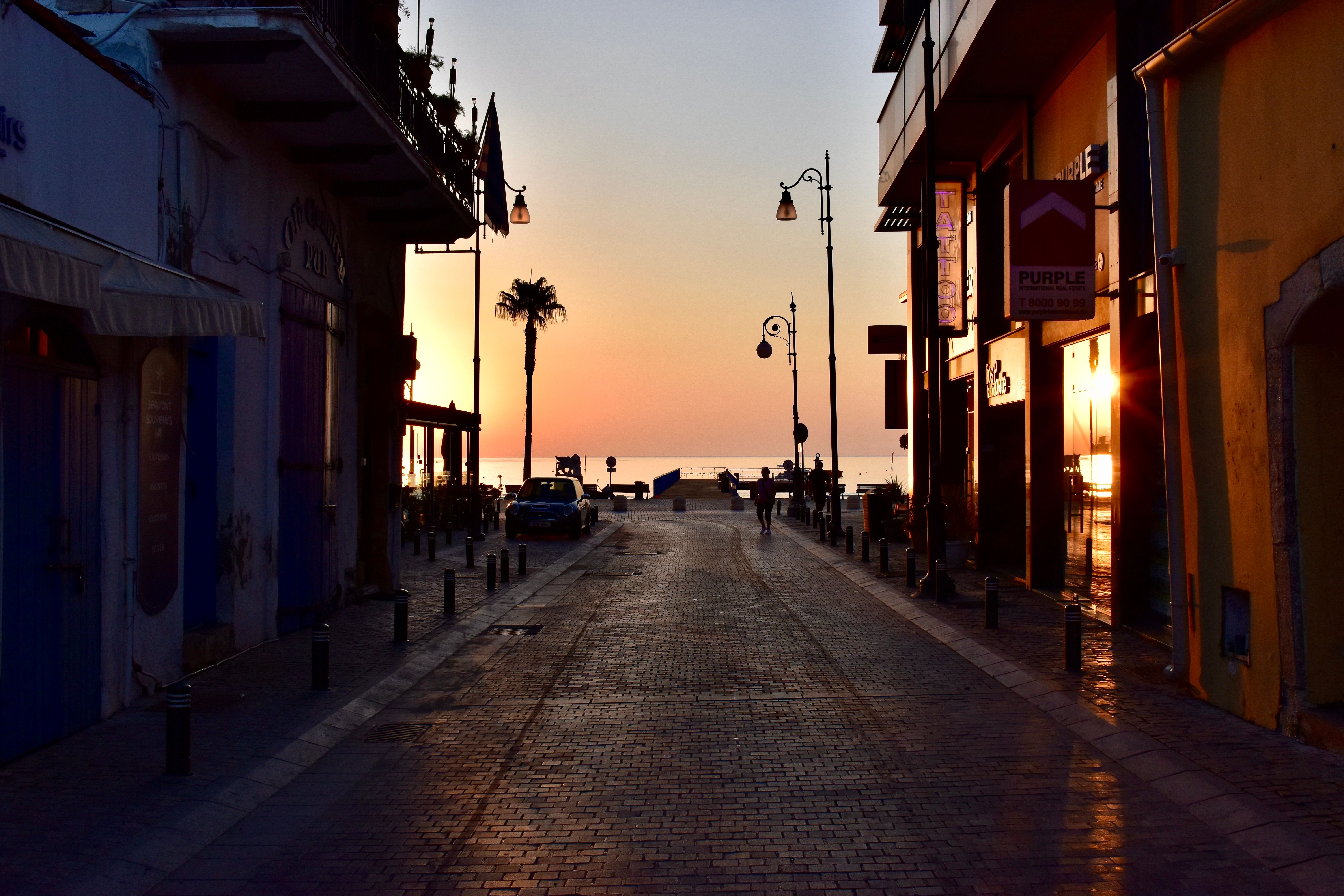 לרנקה: Charming street view in Larnaca, Cyprus during sunset with ocean in the background.