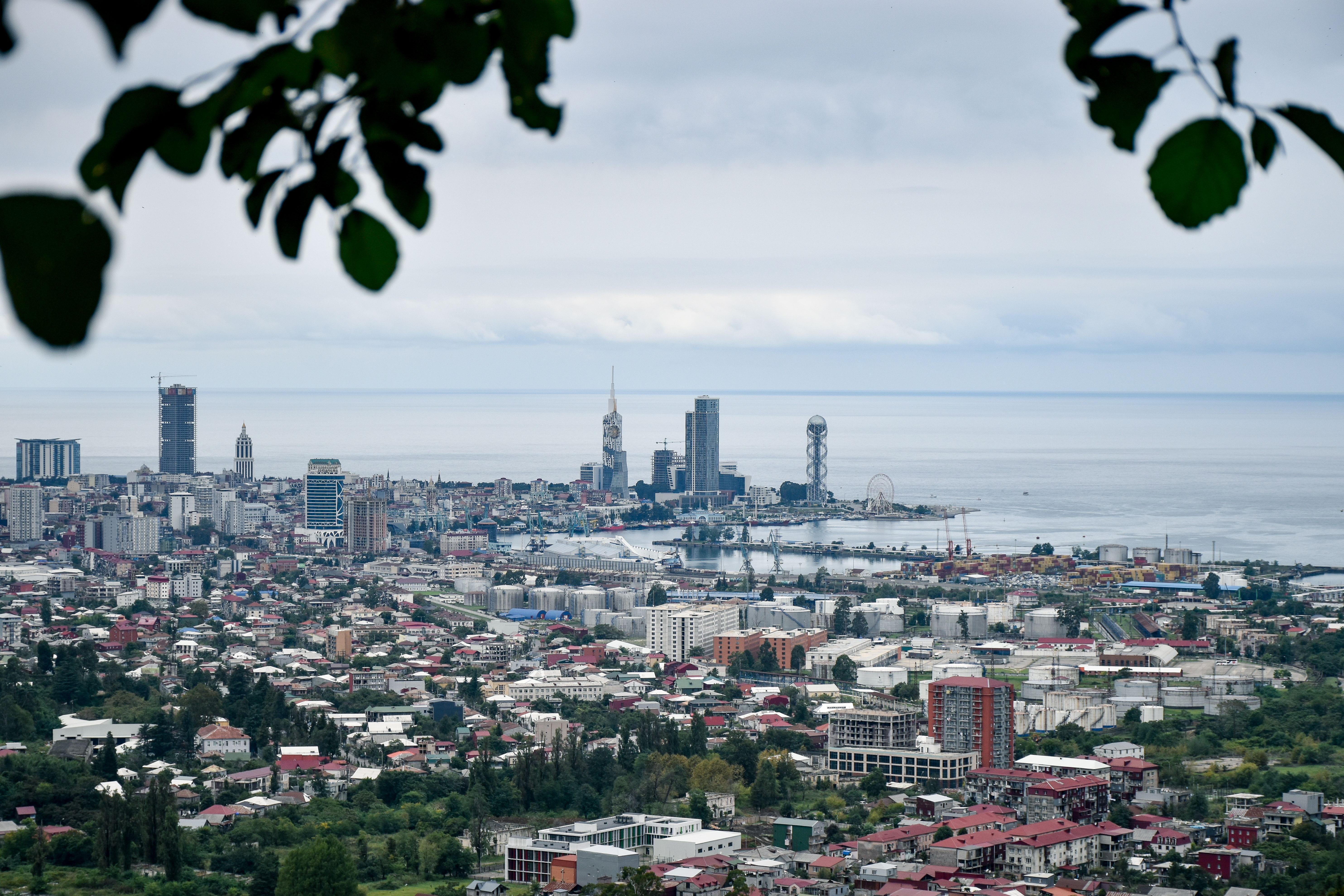 בטומי: Scenic aerial view of Batumi cityscape and the Black Sea with modern architecture and lush greenery.