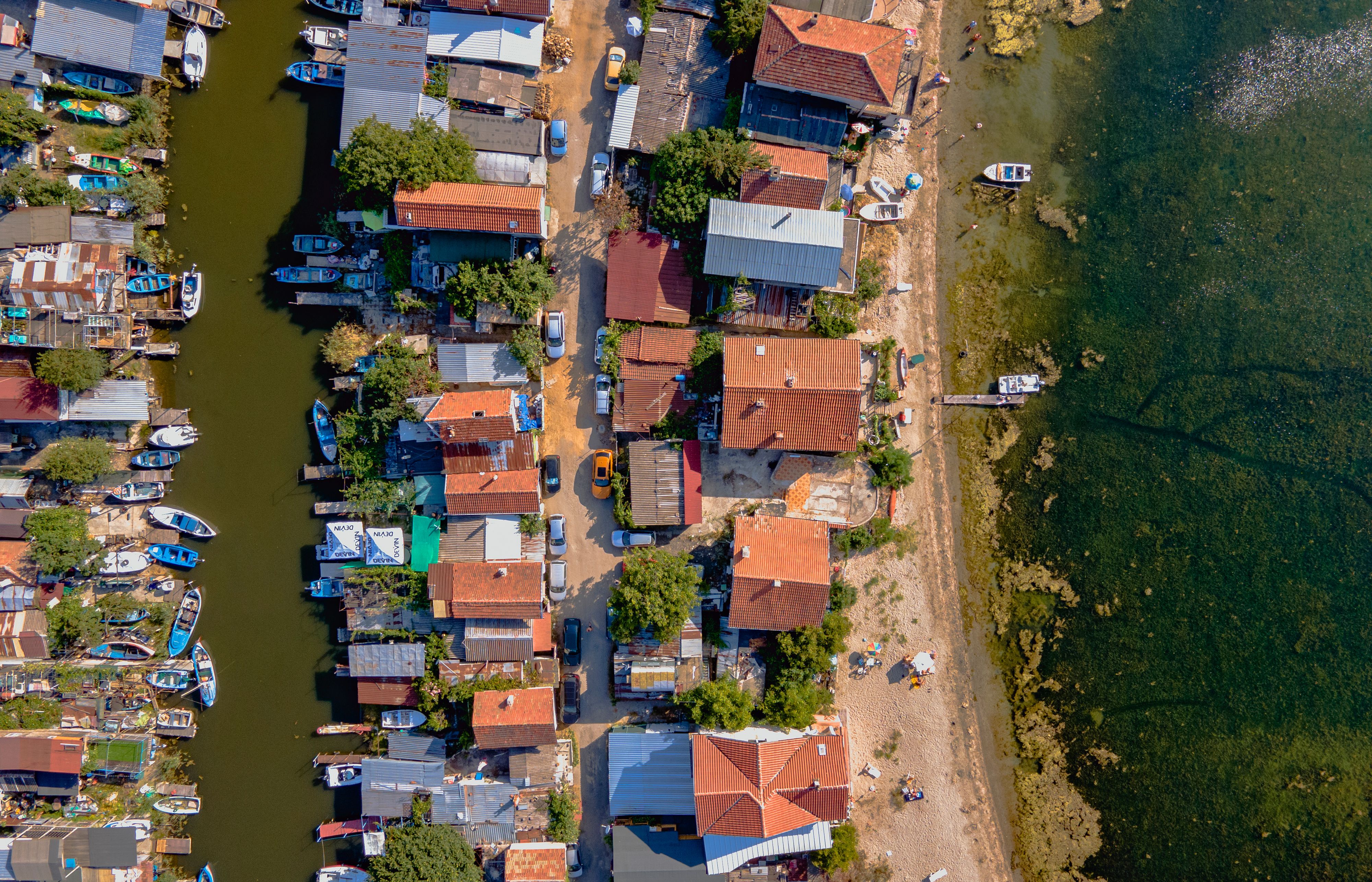 בורגס: A drone captures a colorful coastal village in Burgas, Bulgaria alongside serene waters.