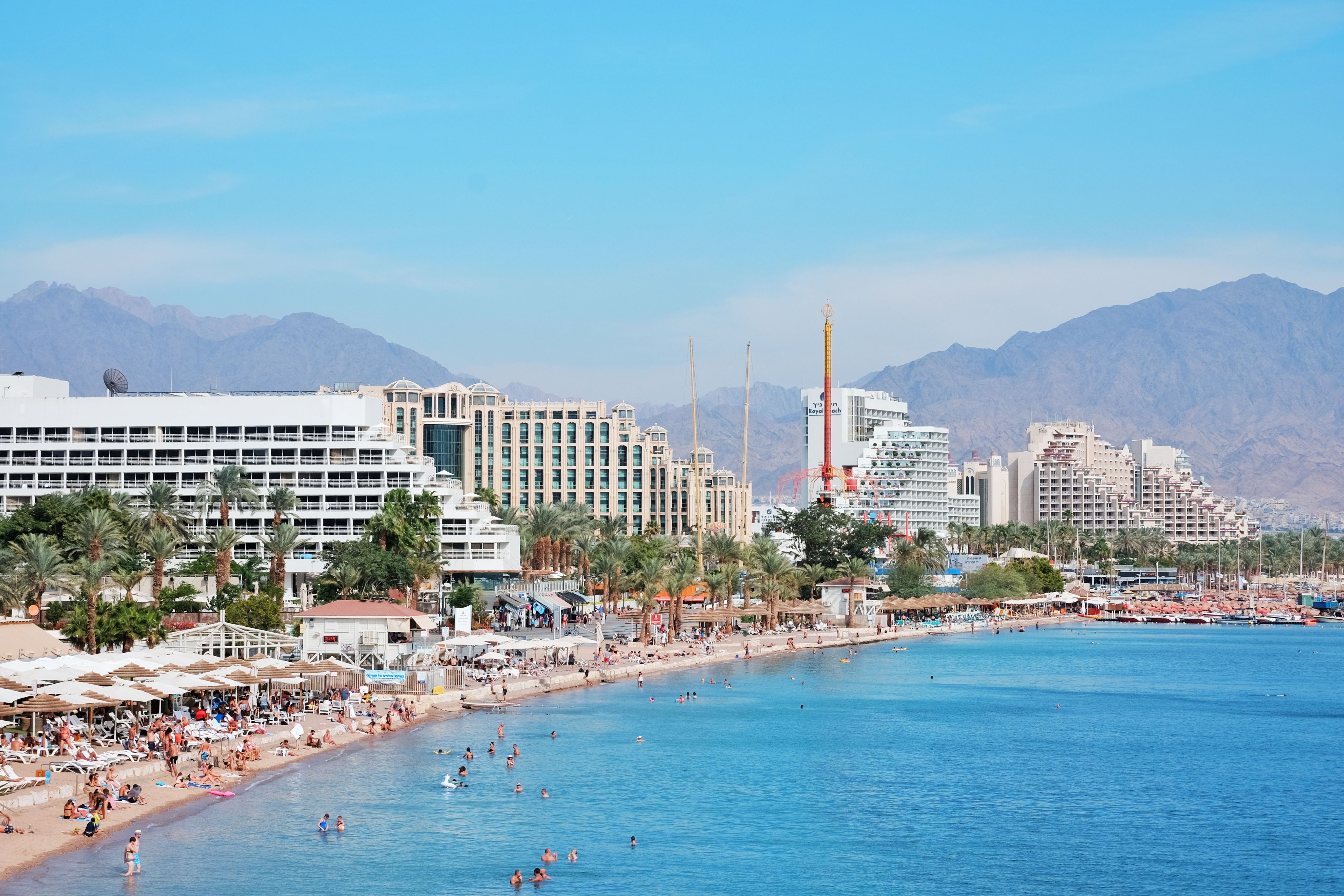 אילת: Scenic view of Eilat's coastal hotels and beach with distant mountains.