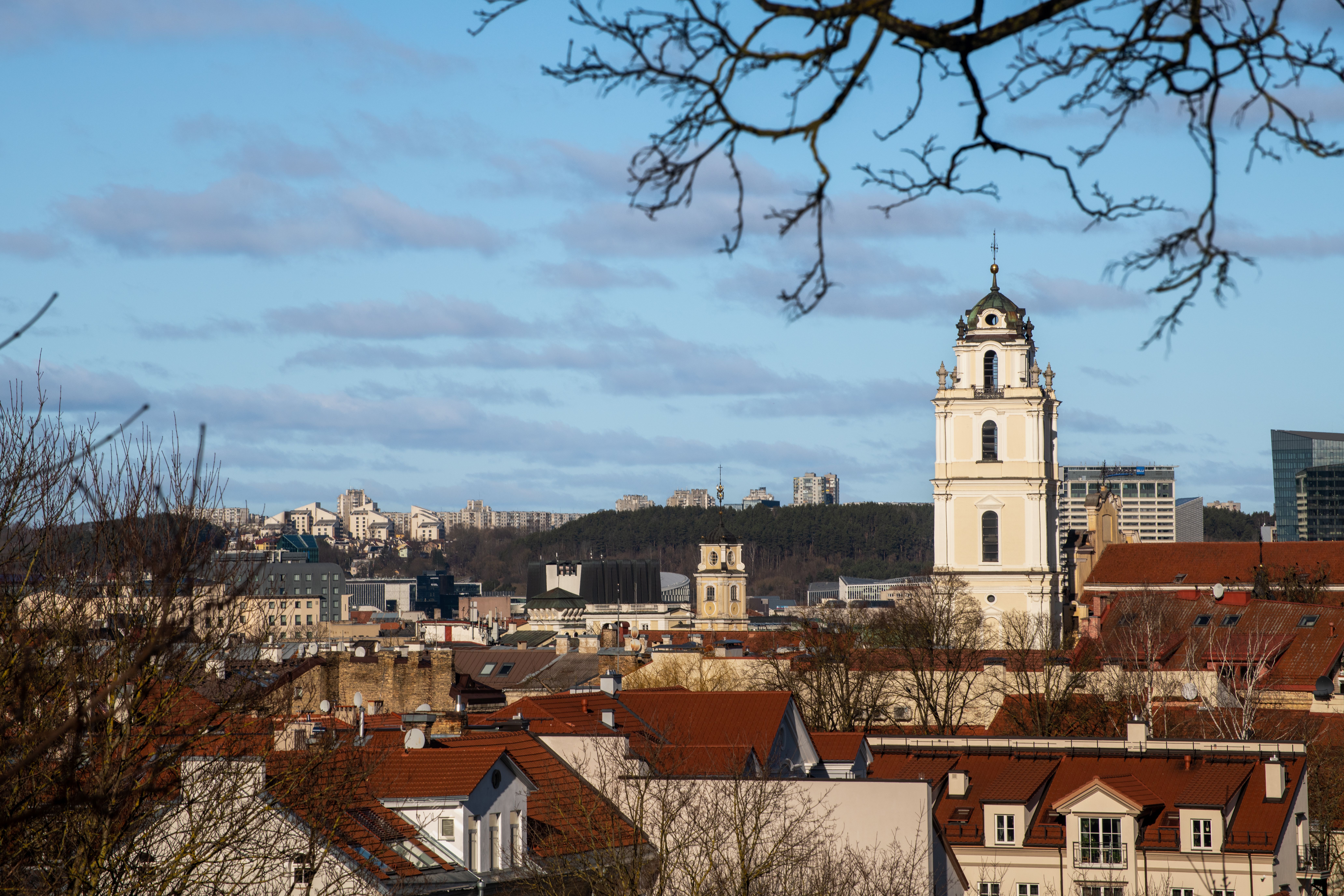 וילנה: A beautiful view of Vilnius city featuring historic architecture and a prominent church tower under a clear sky.