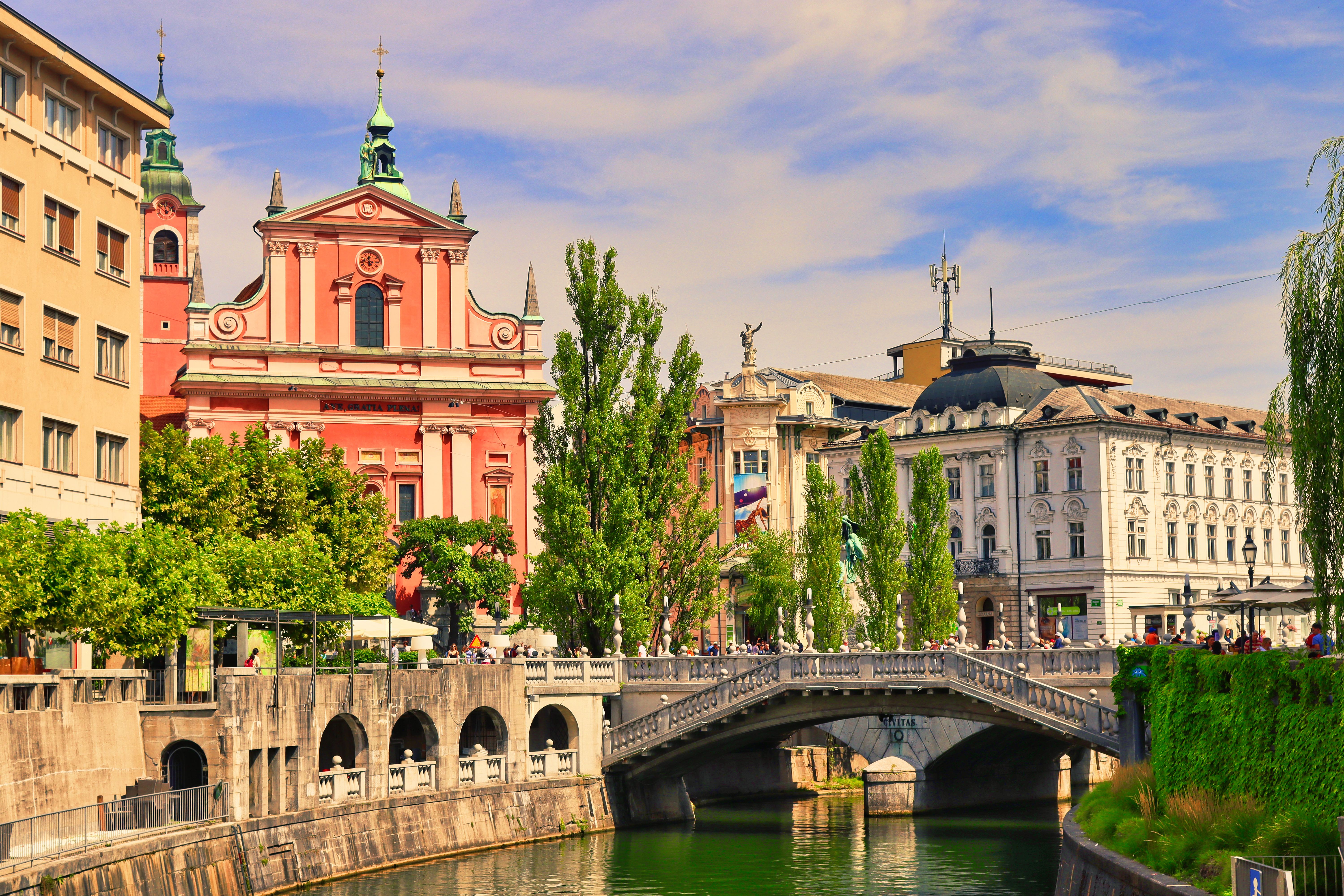 לובליאנה: Explore Ljubljana's vibrant cityscape with the Triple Bridge and Franciscan Church on a sunny day.