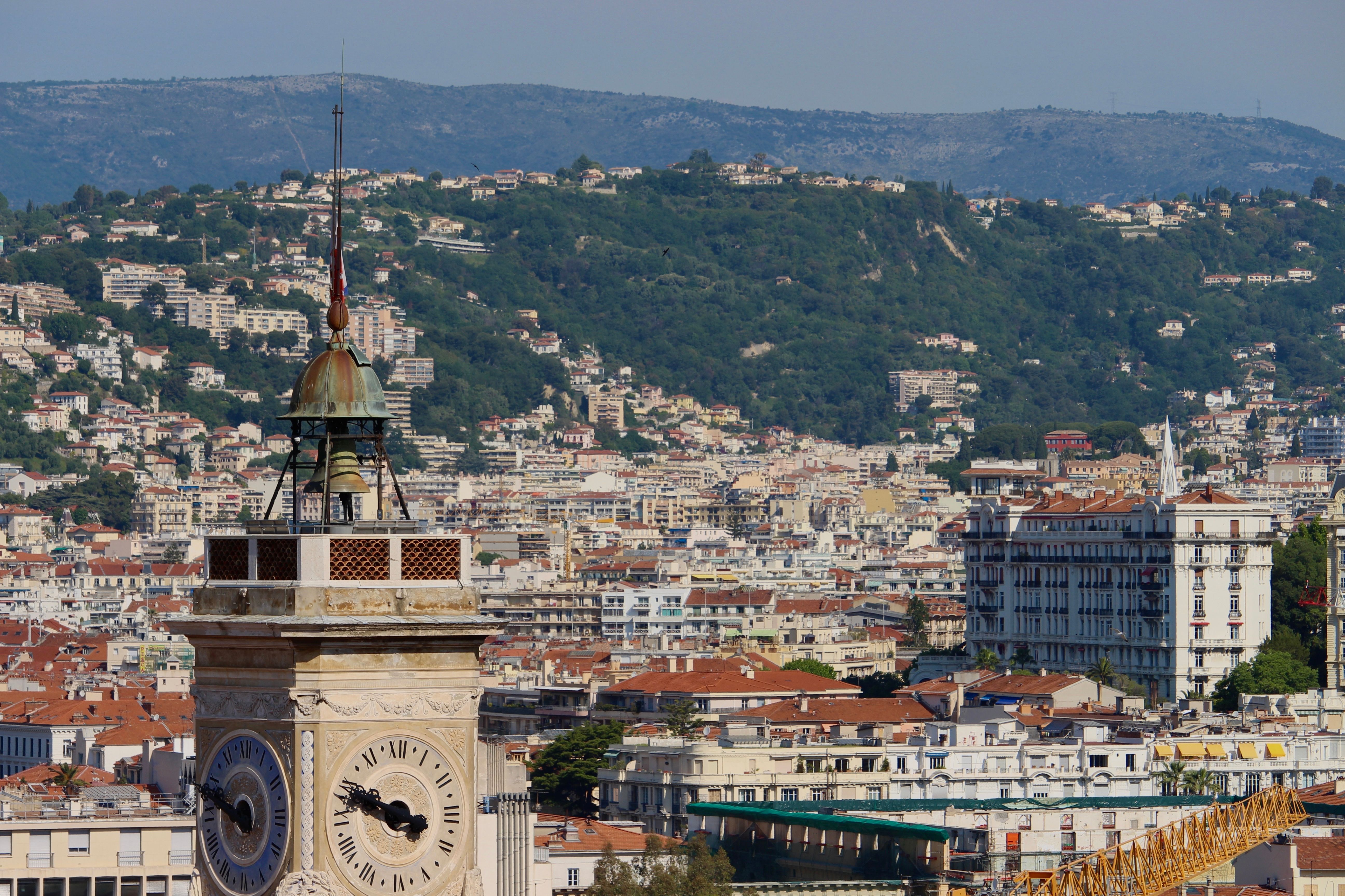 ניס: A stunning view of a historic clock tower with the cityscape of Nice, France in the background.