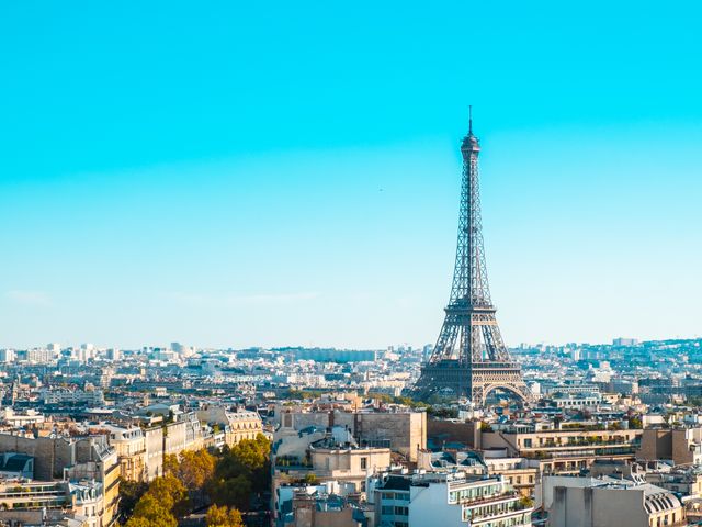 פריז: Eiffel Tower overlooking the cityscape of Paris under clear blue skies.