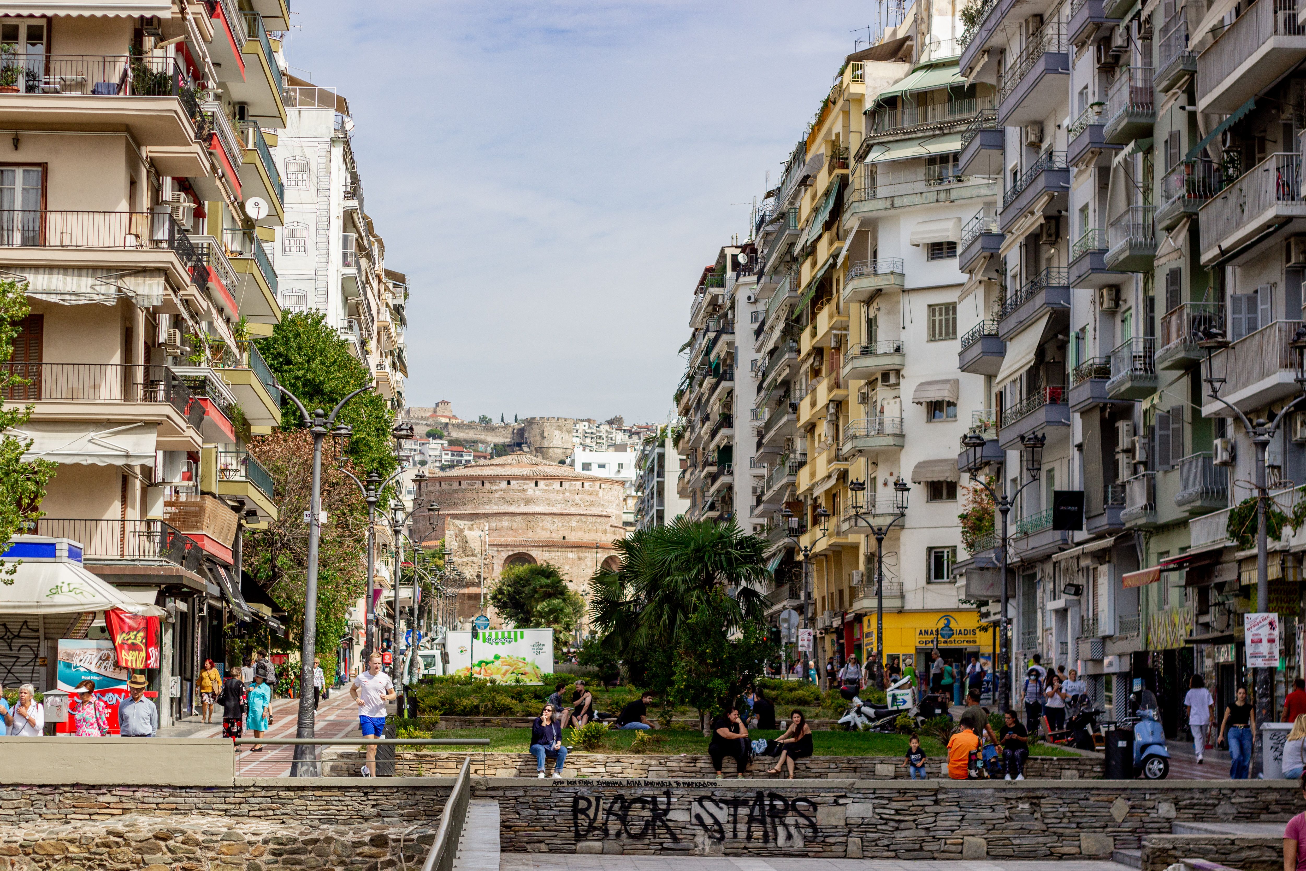 סלוניקי: Bustling street scene in Thessaloniki, Greece with historic Rotunda in the background.
