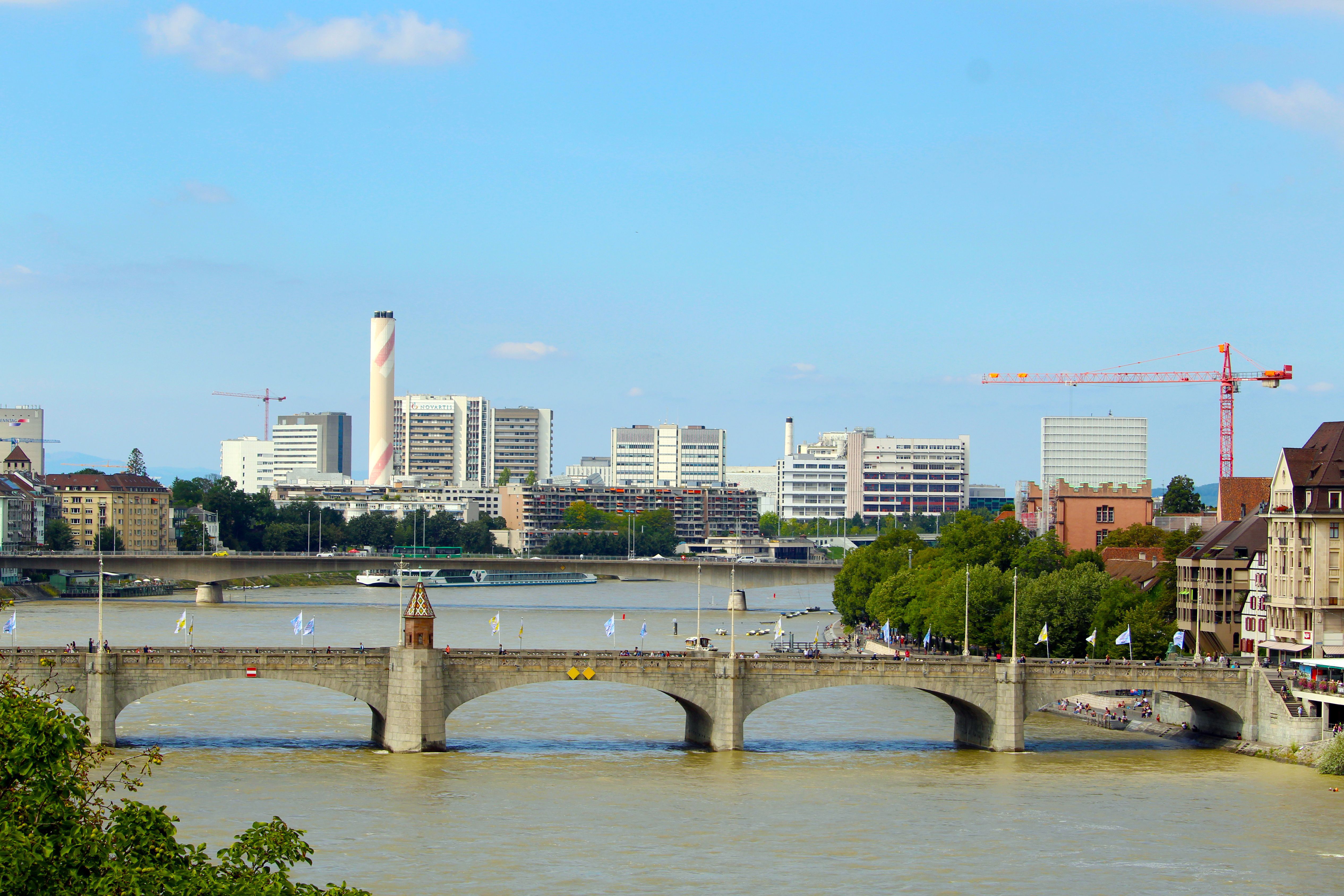 באזל: Beautiful view of Basel's historic bridge over the Rhine River with city skyline in the background.
