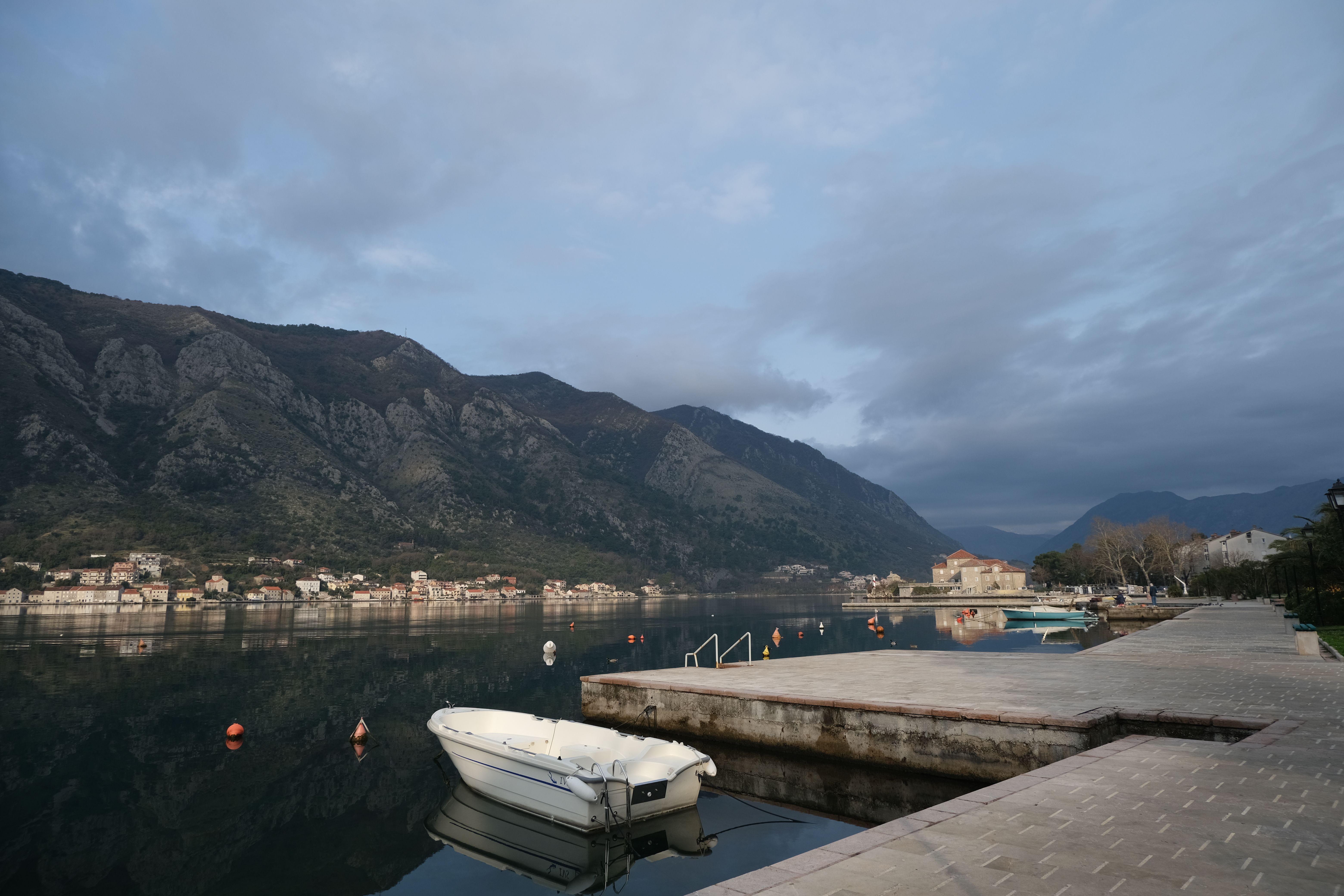 טיבט: Peaceful morning view of Kotor Bay in Montenegro, showcasing calm waters and mountainous backdrop.