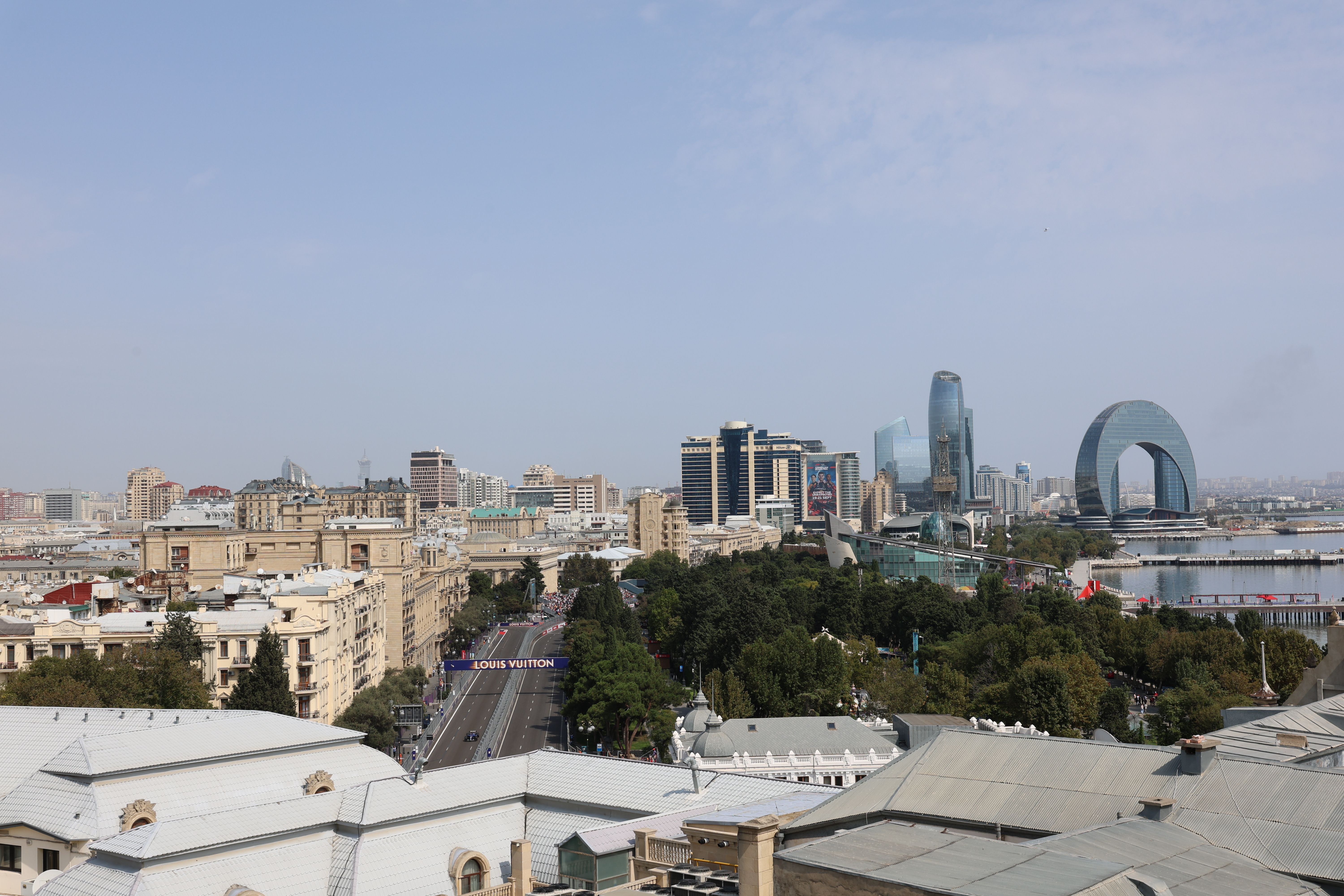 באקו: Aerial view of Baku featuring unique modern architecture and buildings against a clear blue sky.