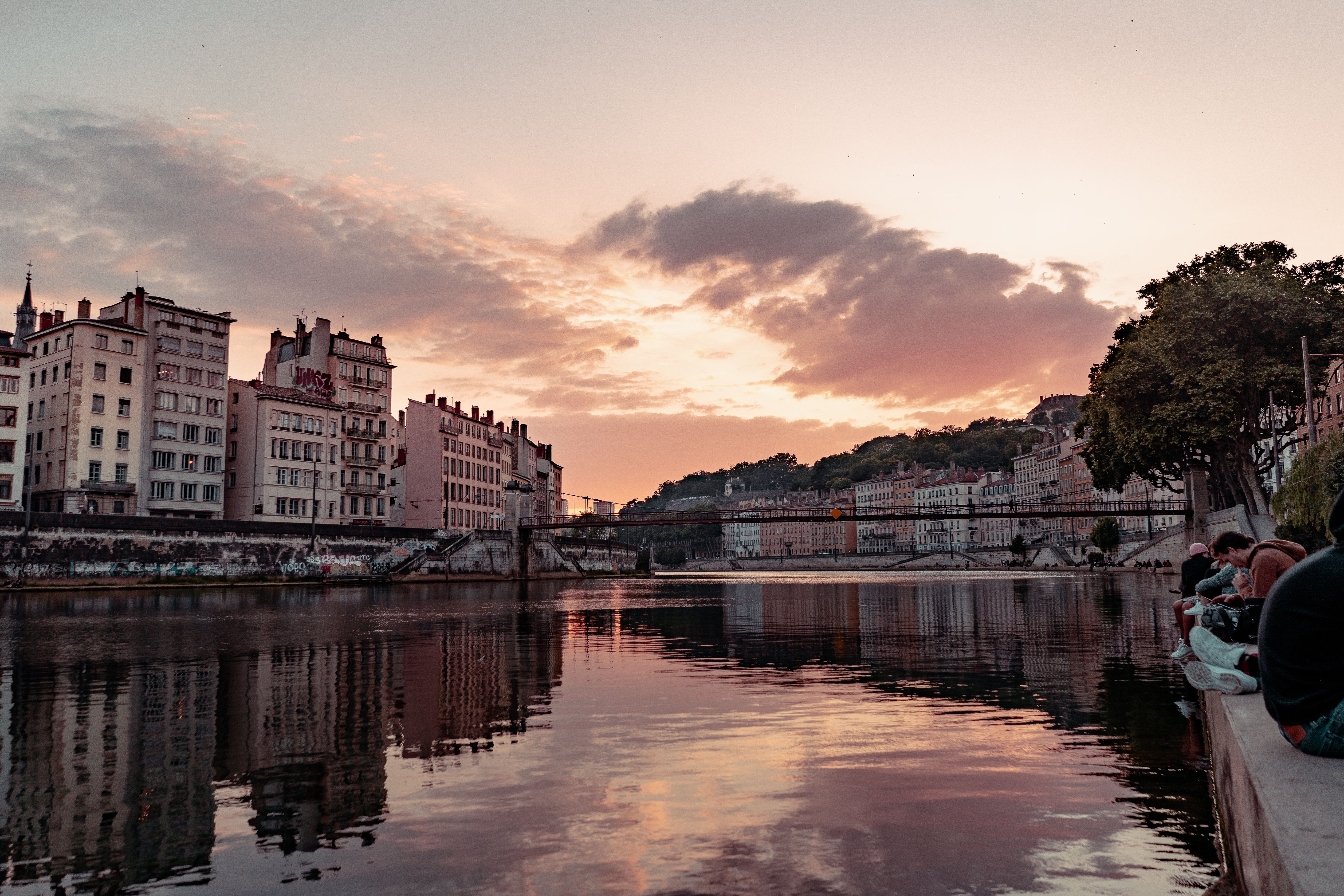 ליון: Beautiful sunset view over the Saone River in Lyon, France, showcasing urban townhouses and reflections.