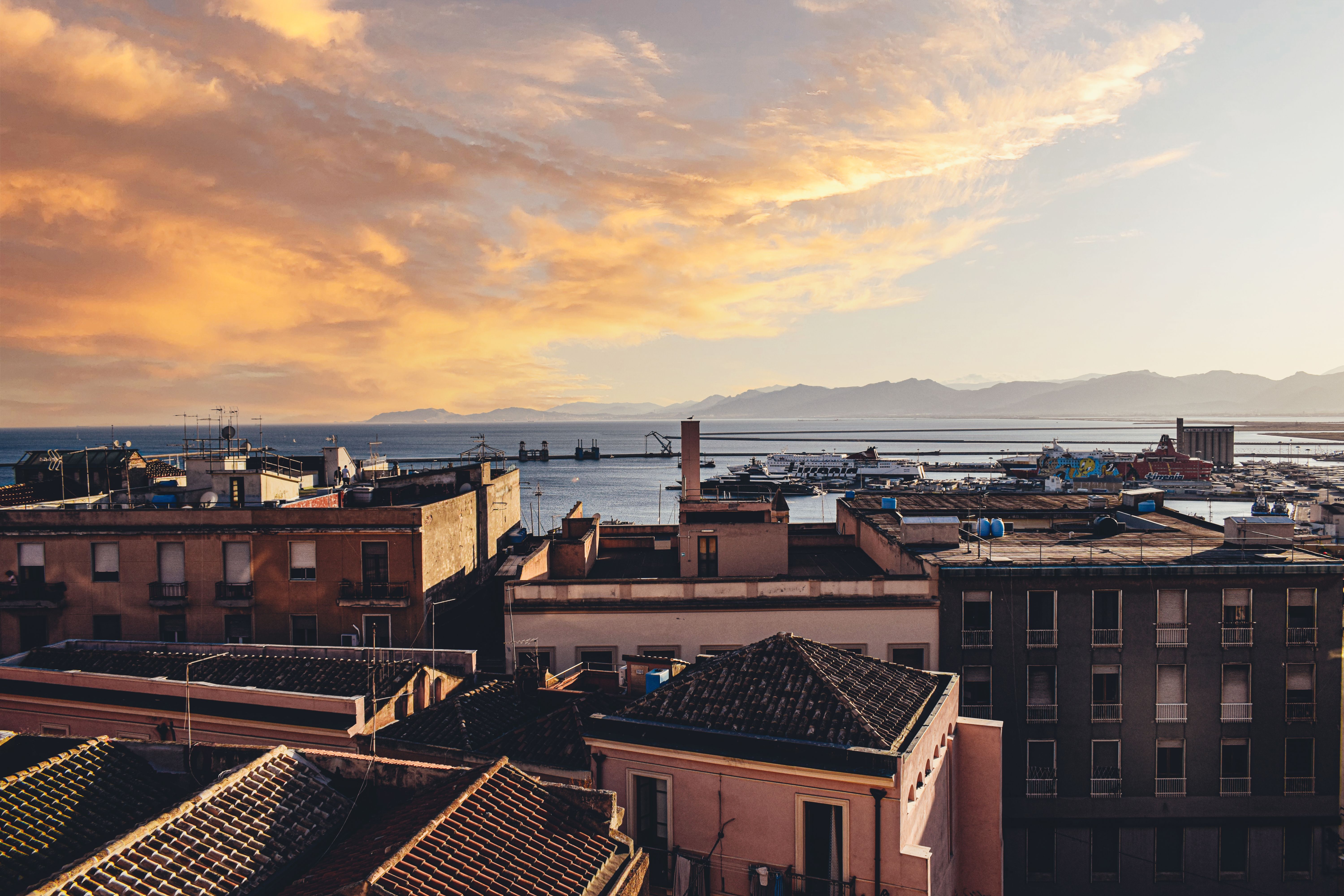 קליארי: Breathtaking sunset over Cagliari, Sardinia with a view of urban architecture and the Mediterranean Sea.